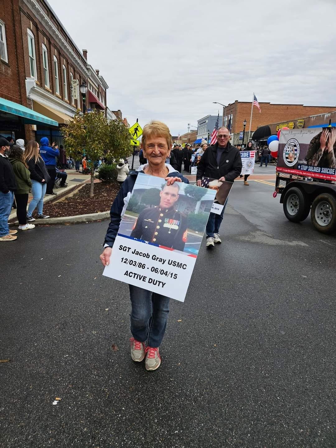 A supporter carrying a photo of a fallen service member during the community walk