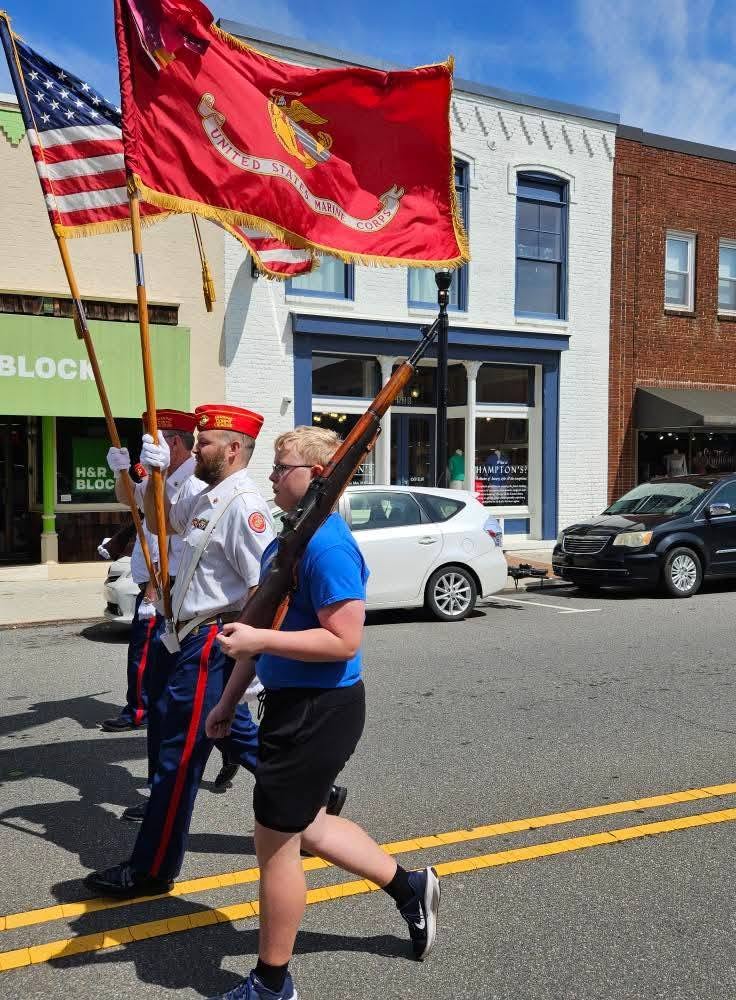 Volunteers carrying American and military flags in the parade