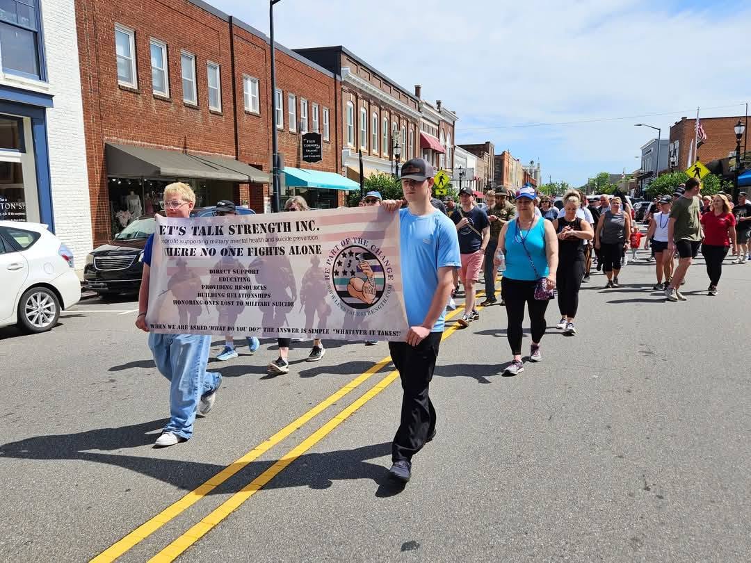 Let's Talk Strength volunteers carrying the organization's banner in the parade