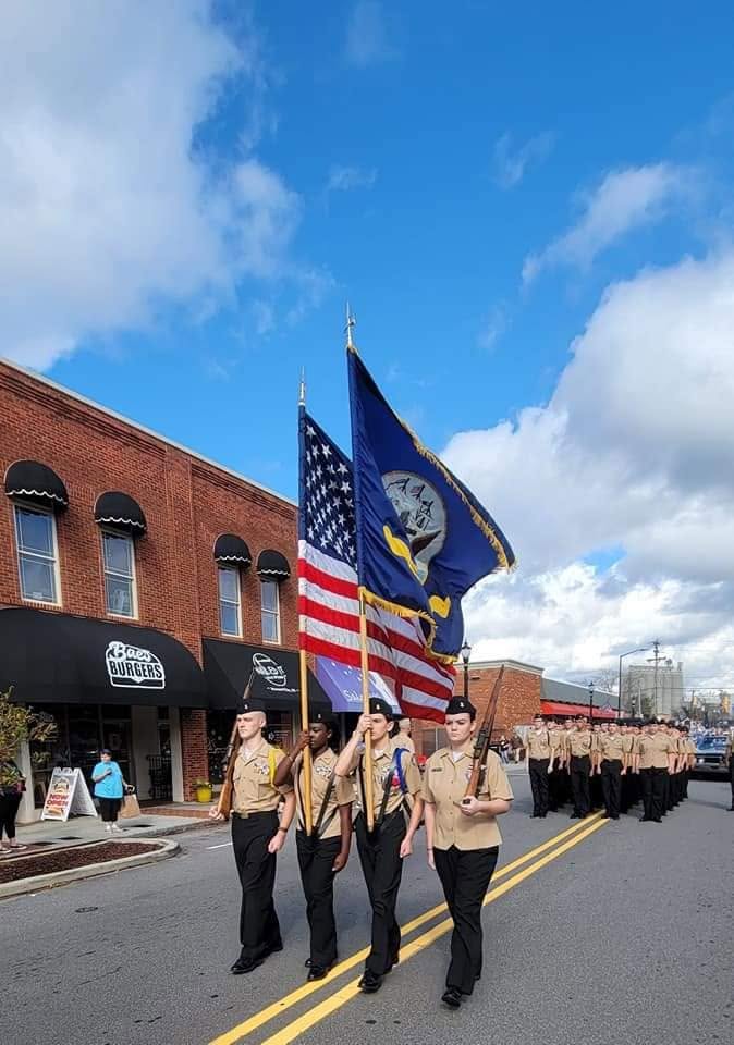 A color guard marching with flags through town
