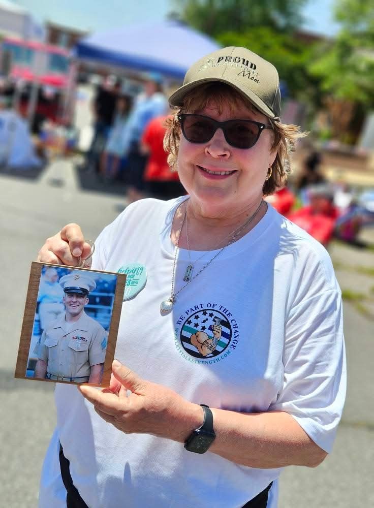 A participant holding a photo of a loved one lost to military suicide