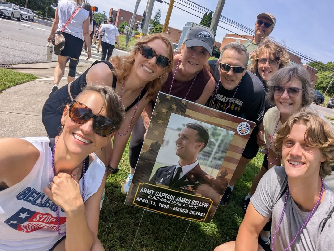 Supporters embracing while holding a memorial photo at a Let's Talk Strength event