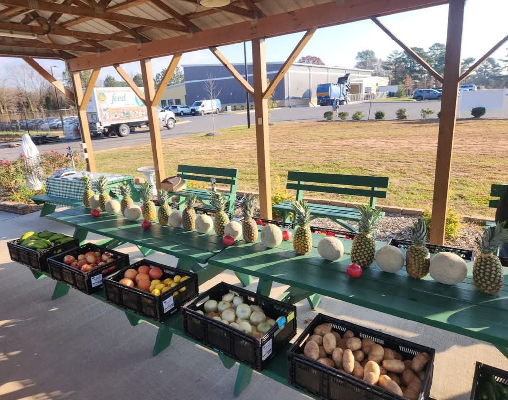 A community food drive table stocked with fresh produce donations