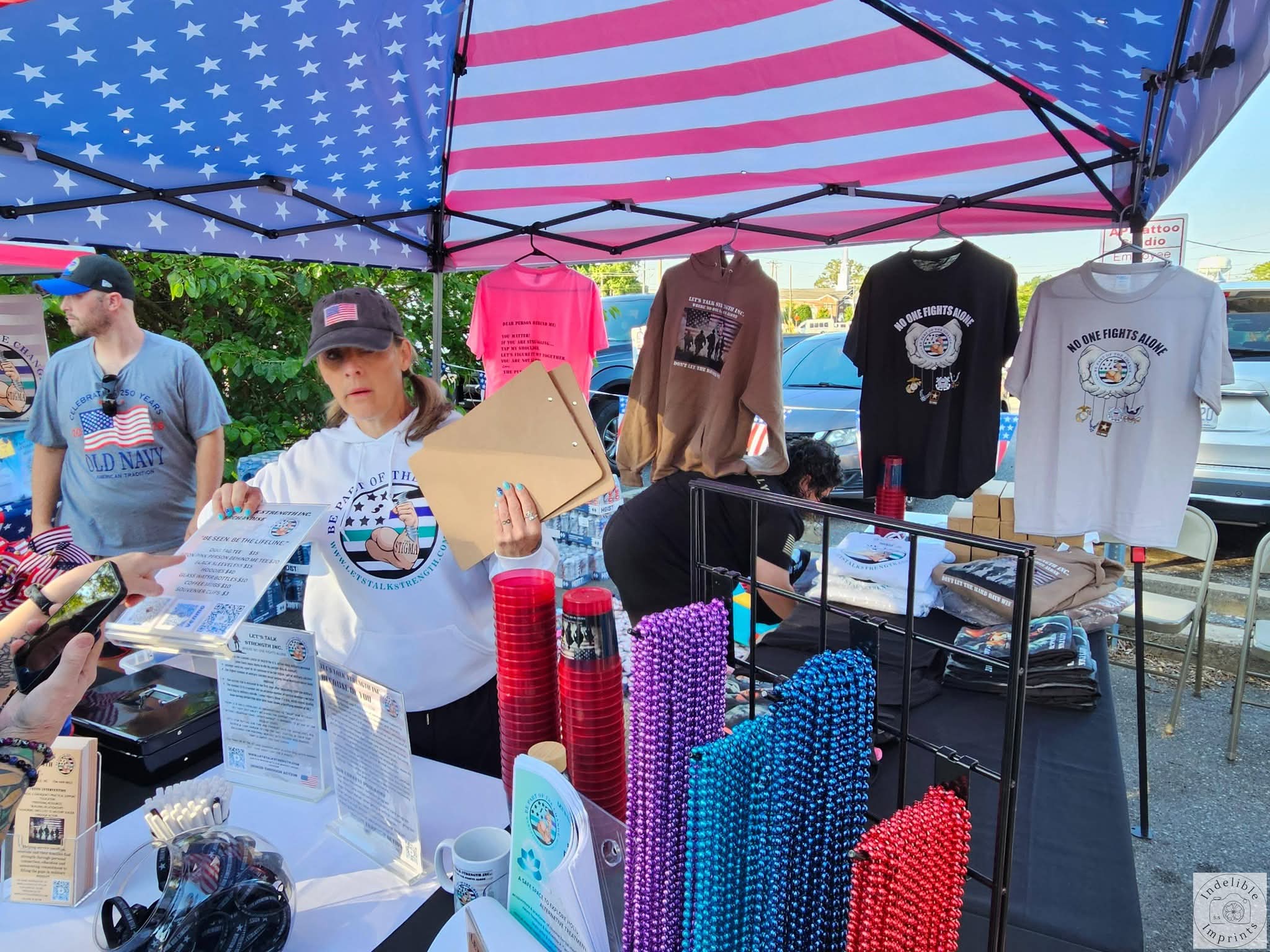 A volunteer at the Let's Talk Strength merchandise table