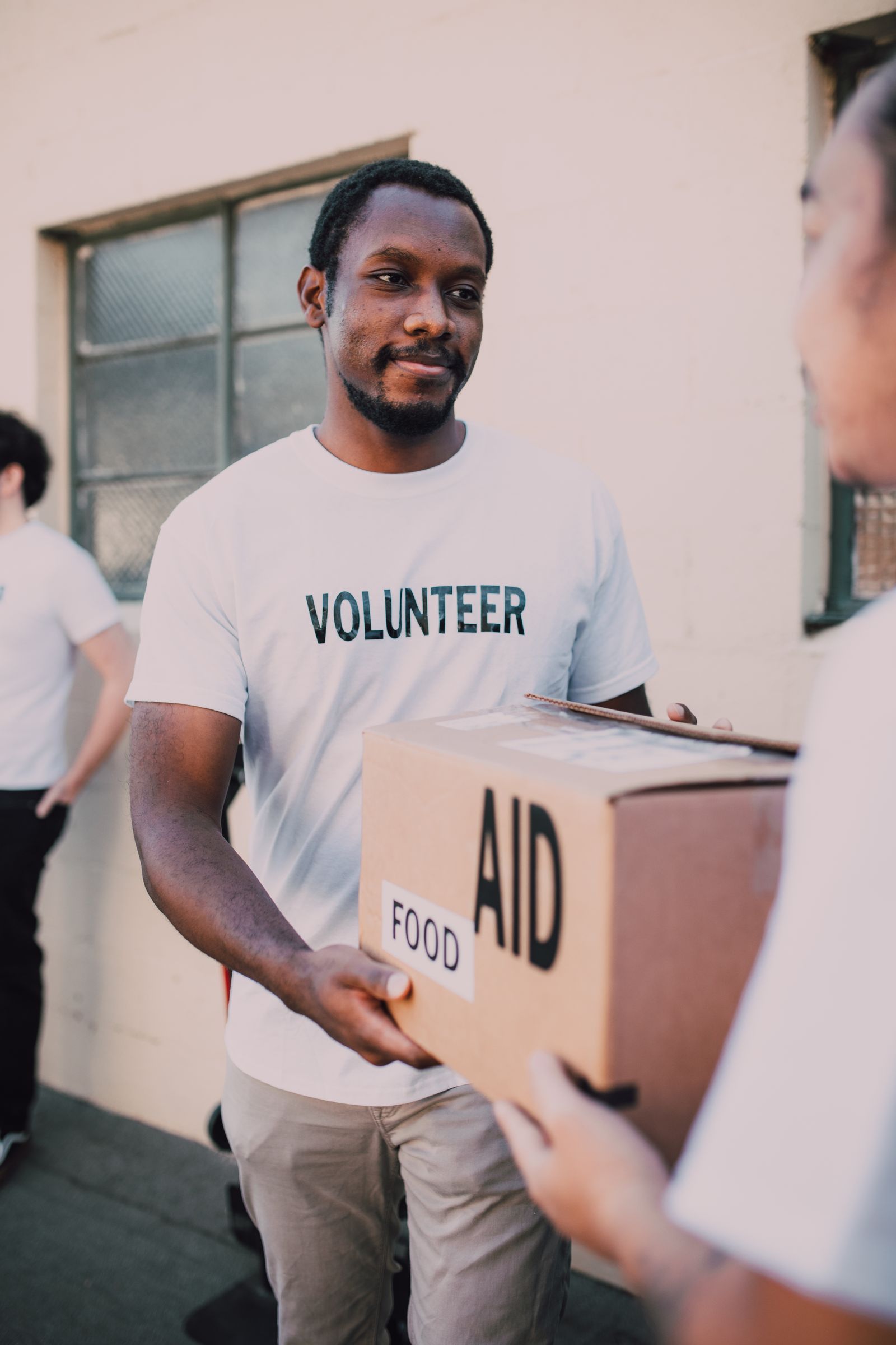 A volunteer handing over a box of emergency food aid